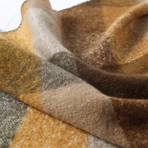 Close-up of soft cashmere-like fabric with warm yellow-brown plaid pattern detail