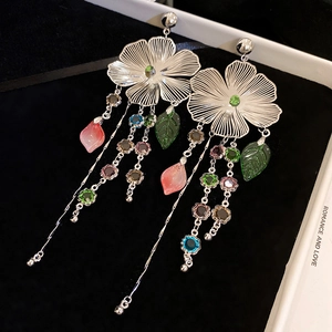 Detail of floral tassel earrings featuring pink petals and multi-colored gemstones