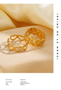 Detailed view of 18K gold plated heart ring and woven texture band on stone surface
