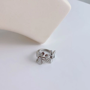 Macro shot of a minimalist silver double flower ring with open petal design details