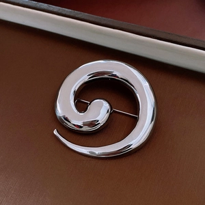 Detailed back view of a silver spiral brooch showing the secure metal pin fastening mechanism