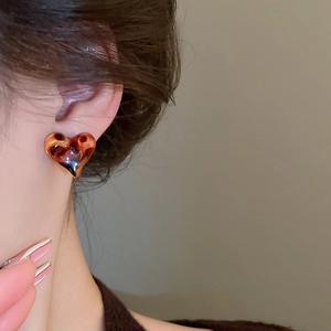 Detailed side view of a heart-shaped resin earring with brown amber leopard pattern