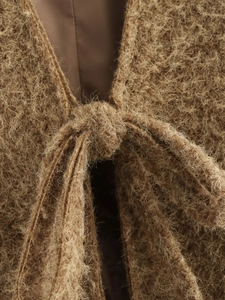 Macro detail of brown fuzzy knit cardigan with lace-up design and soft plush texture