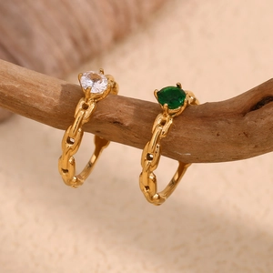 Bagues chaîne plaquées or 18 carats avec cristaux blancs et verts sur bois naturel