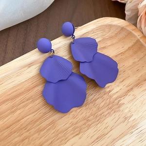 Detail of matte purple flower petal tassel earrings with layered texture and gold links