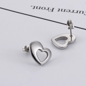 Boucles d'oreilles clous coeur évidé en acier titane poli sur carte d'affichage