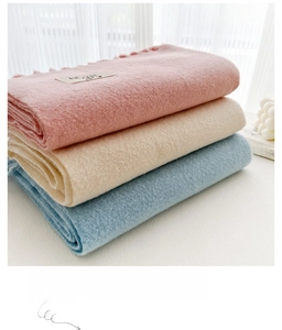 Close-up of soft tassel scarves in pink, beige, and blue with premium brushed texture