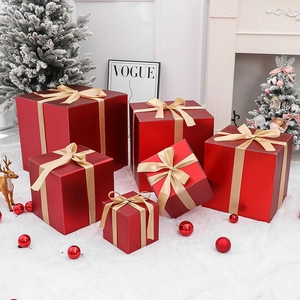 Stack of red Christmas gift boxes with gold ribbons in a festive holiday living room setup
