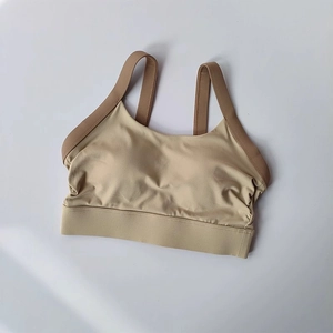Flat lay of seamless beige yoga sports bra with contrasting dark brown wide shoulder straps