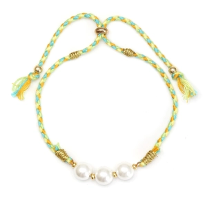 Detail of woven green rope bracelet featuring glass shell pearls and adjustable tassel cord