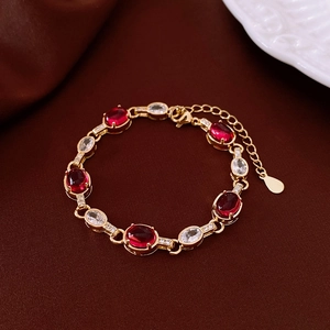 Detail of 18k gold plated bracelet with red cat-eye stones and clear cubic zirconia