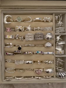 Velvet jewelry box showcasing a variety of vintage silver rings with pearls and gemstones