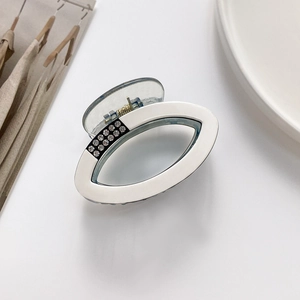 Close-up of an oval hair claw clip with sparkling rhinestones on a white background