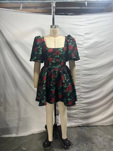 Détail d'une mini robe à col carré avec motif floral rose rouge et manches bouffantes