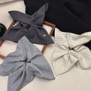 Three-piece set of vintage striped bow scrunchies in grey, blue, and cream with metal charms