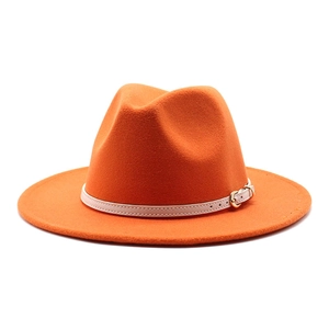 Detail of orange wool fedora hat featuring a white leather band and gold buckle