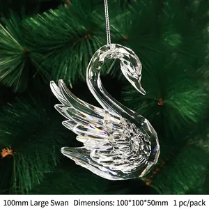 Macro detail of a 100mm faceted crystal swan pendant hanging on a green festive tree