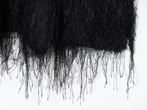 Gros plan des franges noires détaillées sur une robe de mode ajustée