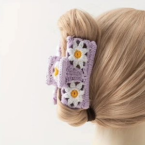 Detail showing hand-knit purple crochet hair claw with delicate white daisy flower