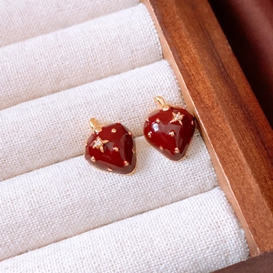 Detail of 18K gold plated strawberry earrings with red enamel and star zircon accents