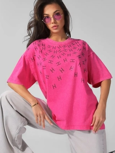 Close-up of pink cotton T-shirt featuring a distinctive black H-letter rhinestone print