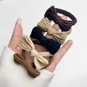 Detailansicht von fünf Haargummis mit Schleife in Kaffee, Khaki, Schwarz, Beige und Hellbraun