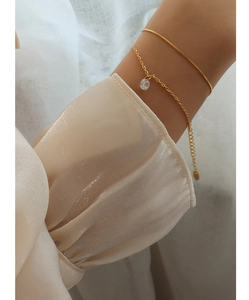 Detail of double-layer gold titanium bracelets with cubic zirconia and adjustable chain