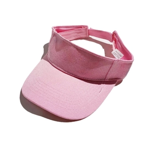 Detailed texture of pink denim fabric on a sport visor hat with a small wash label