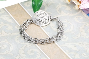 Detail of silver Hamsa Hand double chain bracelet on a vintage textured background