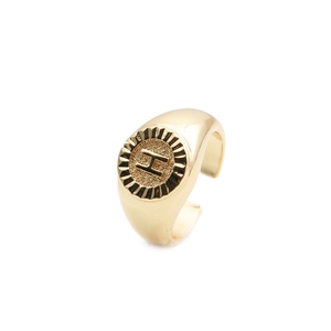 Macro shot of gold plated adjustable ring with a circular base engraved letter H