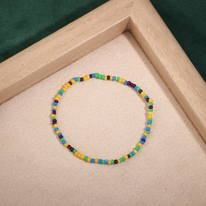 Detailed close-up of colorful handmade seed bead bracelet on beige textured fabric
