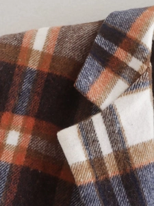 Close-up of orange and navy plaid wool coat collar showing textured brushed fabric detail