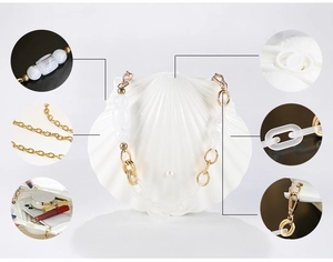 Detail of gold metal chain strap with white acrylic links for stylish shell evening bags