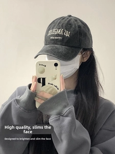 Mirror selfie showing a person wearing a vintage washed cotton baseball cap in charcoal grey