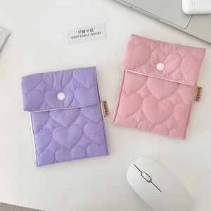 Detailed view of quilted heart pattern on pink and purple mini pouches with snap buttons
