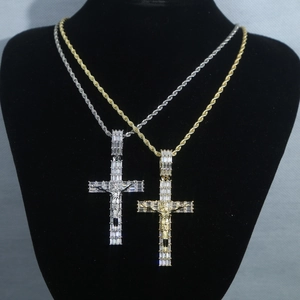 Dettaglio di pendenti a croce in oro e argento con zirconi su catene a corda