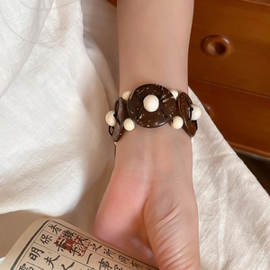 Close-up of coconut shell and wood beads on a retro ethnic style beaded bracelet
