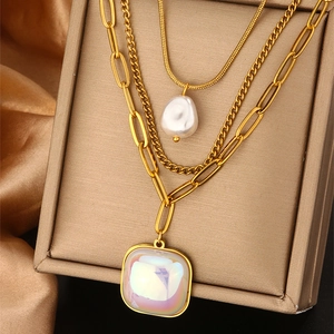 Layered gold necklace with baroque pearl and iridescent square stone pendant