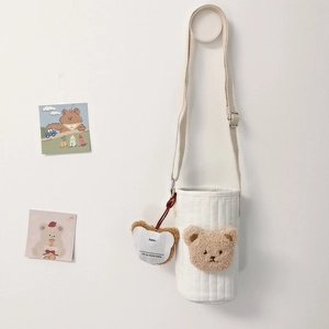 Detailed close-up of a quilted water bottle bag with a cute plush bear head and name tag