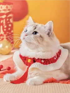 Gros plan du collier tricoté pour animaux rouge et blanc avec perles et pompons