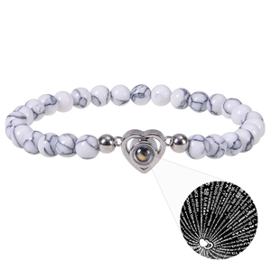 Macro detail of silver heart pendant with projection stone on zebra stone beads