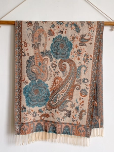 Detailed view of paisley and floral patterns on an ethnic style fringed cashmere scarf