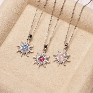 Detalle de tres collares de sol con centros de ópalo de colores vibrantes en un joyero.