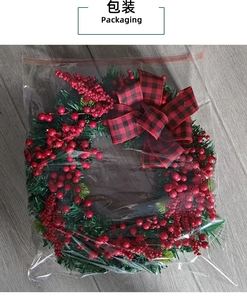 Detailed packaging view of a Christmas wreath with red berries and plaid bow on wood floor