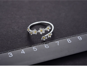 Macro shot of S925 silver forget-me-not ring showing 20mm flower size on a scale
