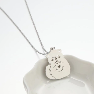 Close-up of cute cartoon cat pendant with heart detail on a silver stainless steel chain