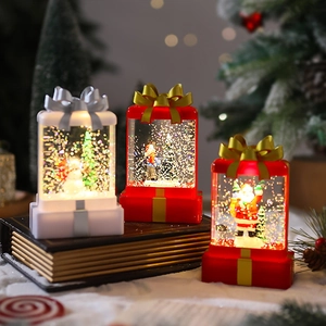Christmas gift box lanterns with Santa and snowman scenes on vintage books background