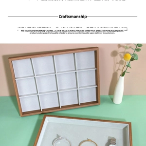 Detailed view of 12-slot rosewood jewelry display tray with soft grey velvet lining