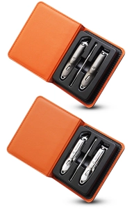 Close-up of stainless steel manicure sets with orange leather cases and metal tools