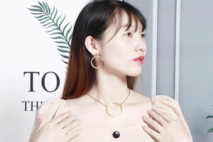 Close-up of model wearing gold hollow geometric circle necklace and earring jewelry set